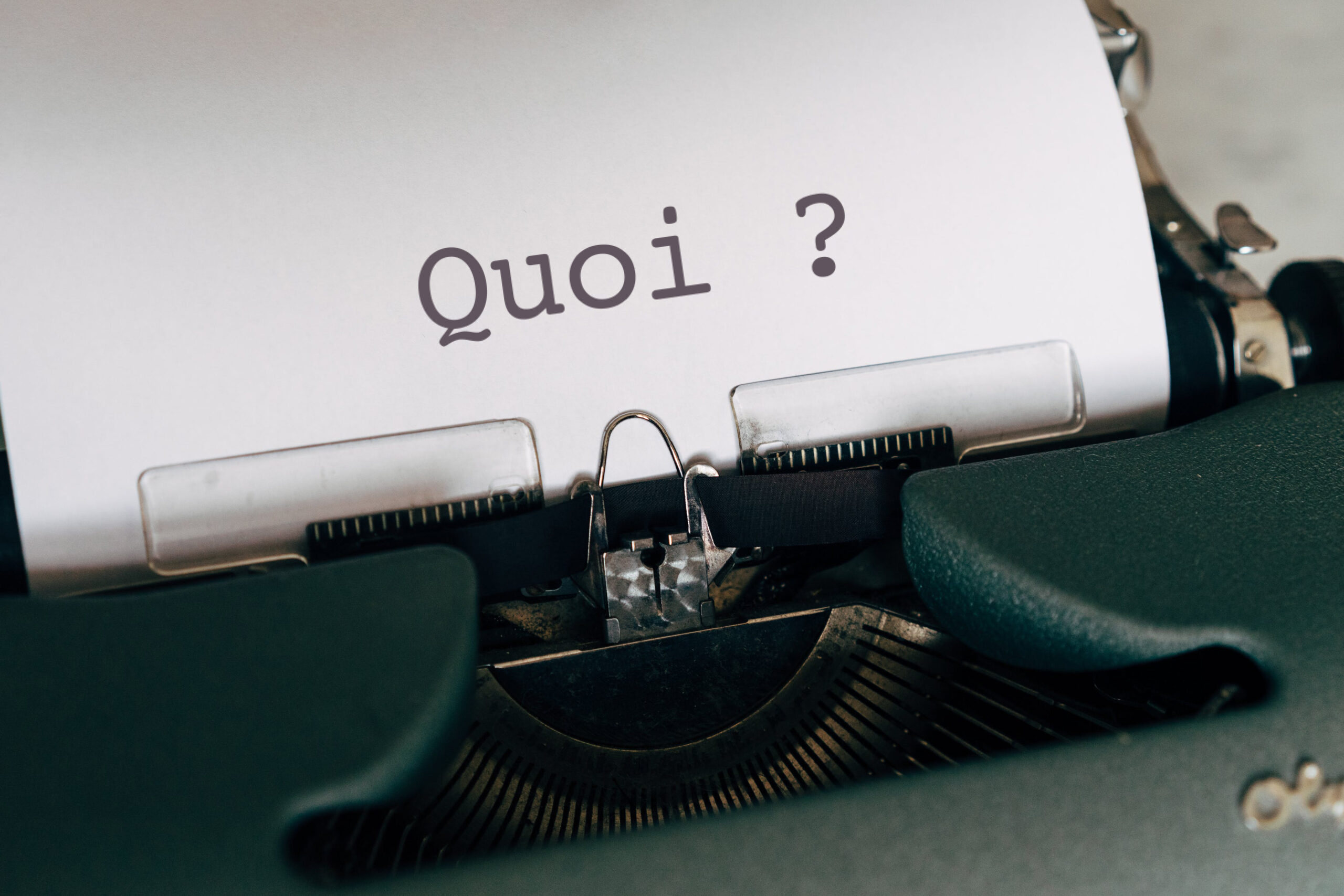 Machine à écrire avec sur le papier écrit "Quoi ?"